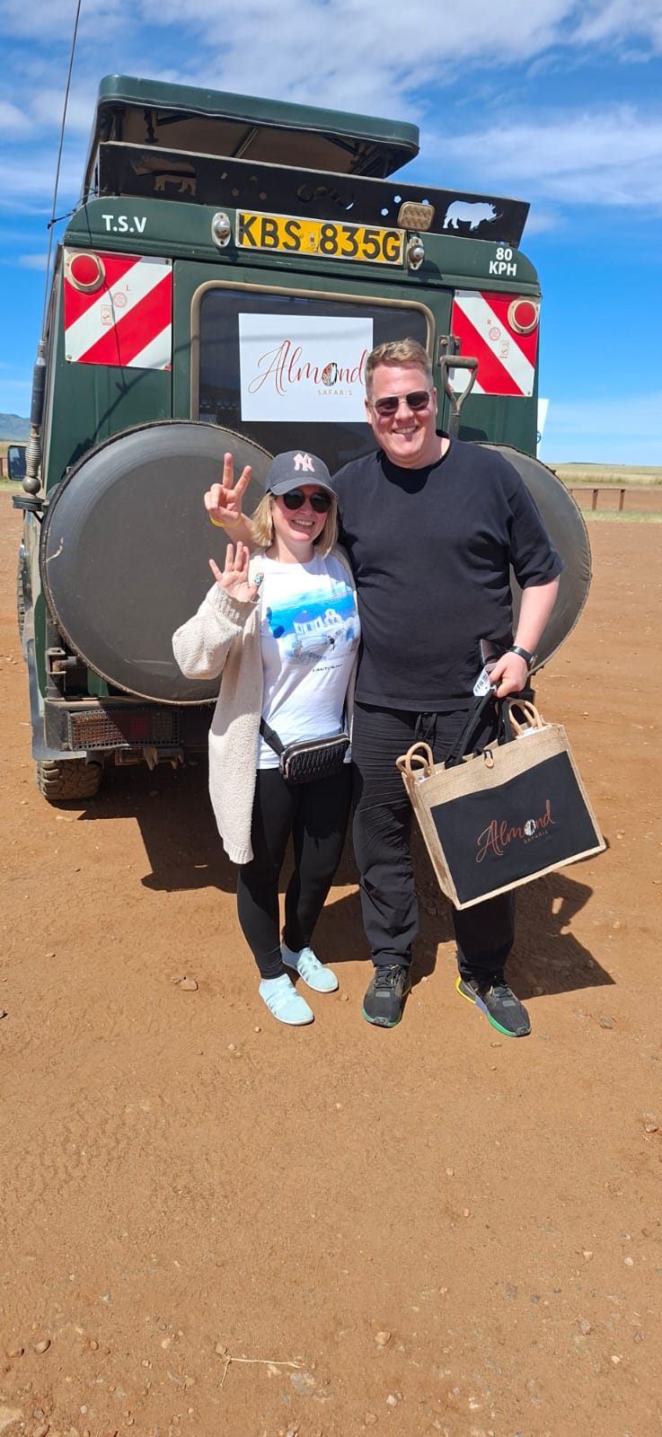 Almond Safaris guests with our safari Land Rover in the Maasai Mara